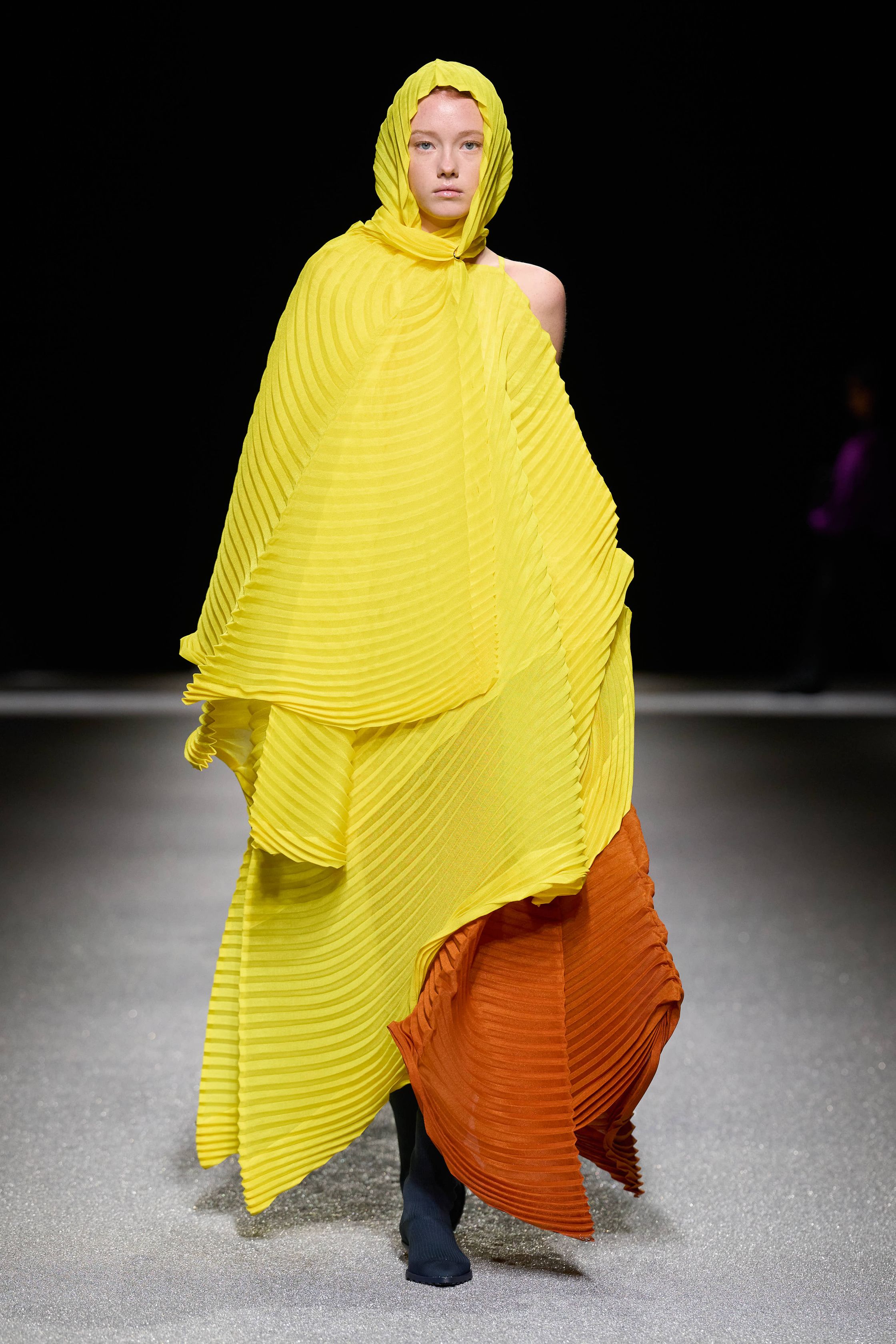 Issey Miyake 这一季把“留白”做成了真正可被看见的力量：黑白灰的大面积静默、宽松针织与褶皱结构先建立禅意秩序，随后以明黄、亮粉与雕塑化体量突然打破沉静，让衣服像在呼吸，也像在生长。它不是简单的极简主义，而是一种把工艺、身体与空间关系重新推向前台的诗性实验-顽石频道趋势研究
